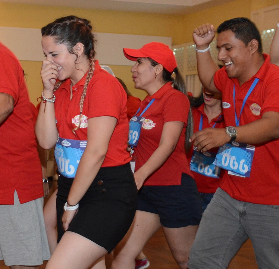 Participantes con dorsales celebrando durante una actividad de integración en un salón