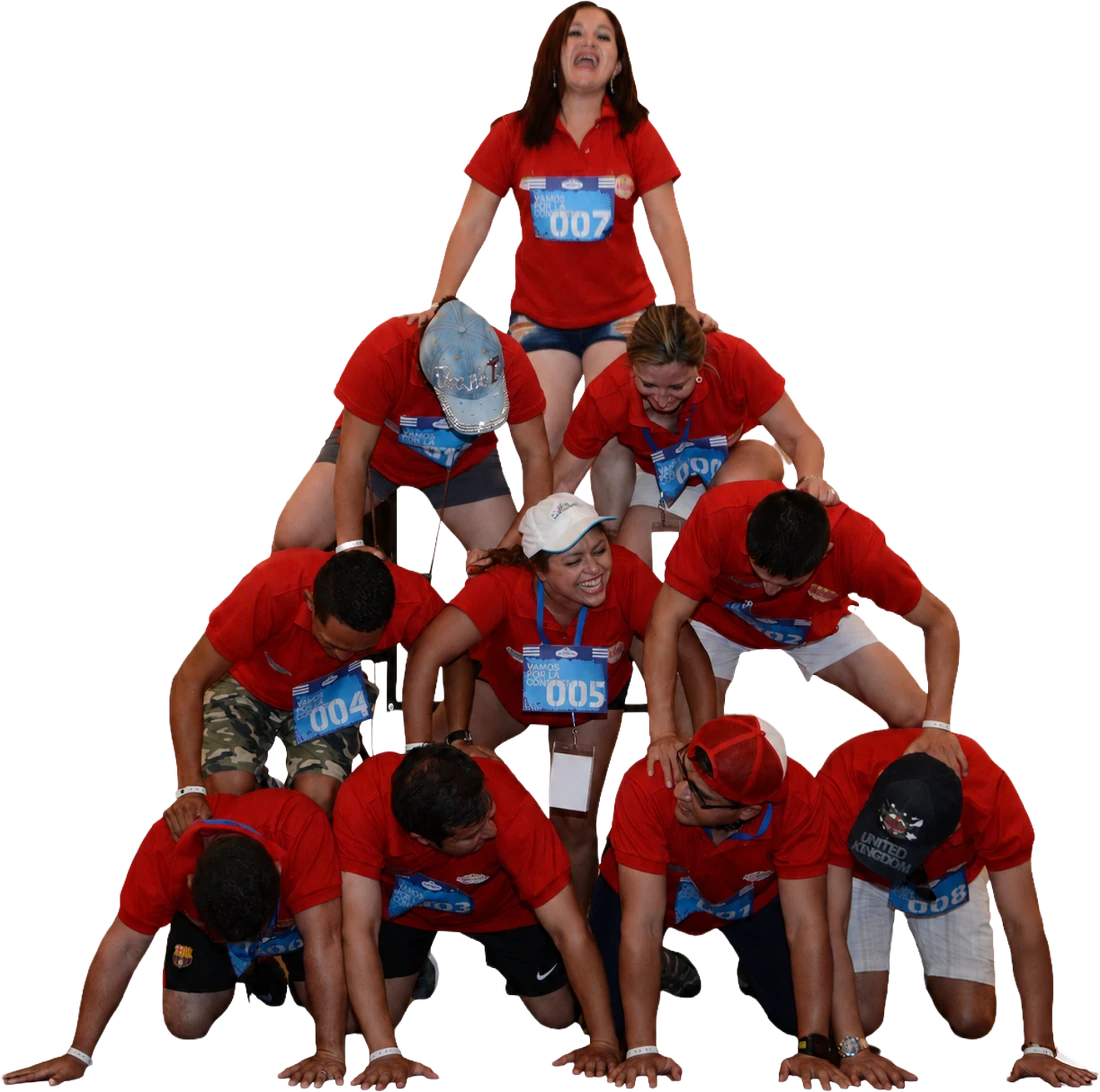 Equipo corporativo formando una pirámide humana de cuatro niveles con dorsales durante una actividad de Team Building LATAM