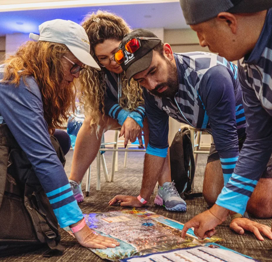 Cuatro colaboradores analizando juntos un mapa durante un taller de integración